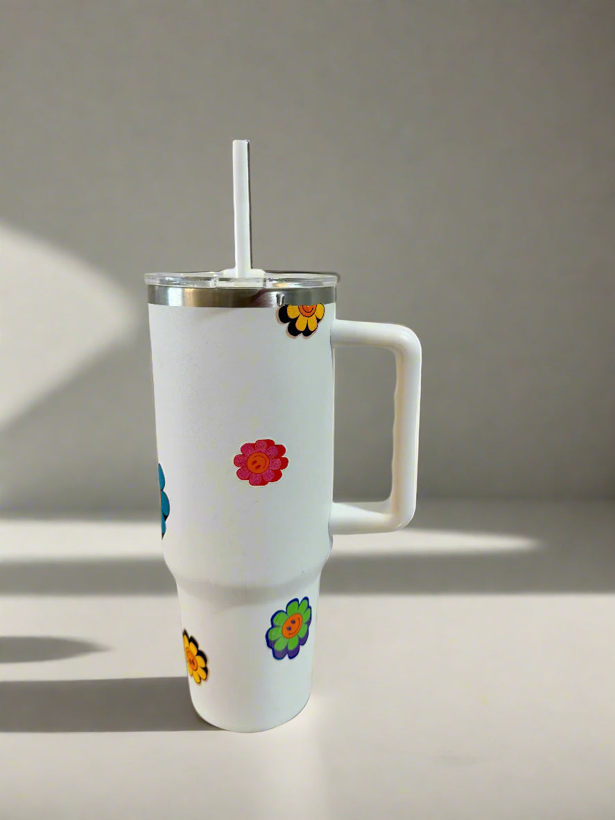 White tumbler with colorful flower stickers on a tiled floor