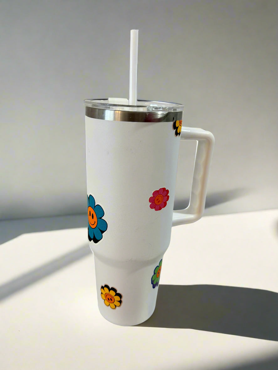 White tumbler with colorful flower designs on a tiled kitchen counter