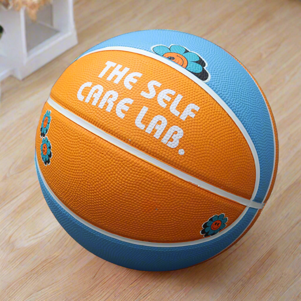 basketball with The Self Care Lab branding in orange and blue